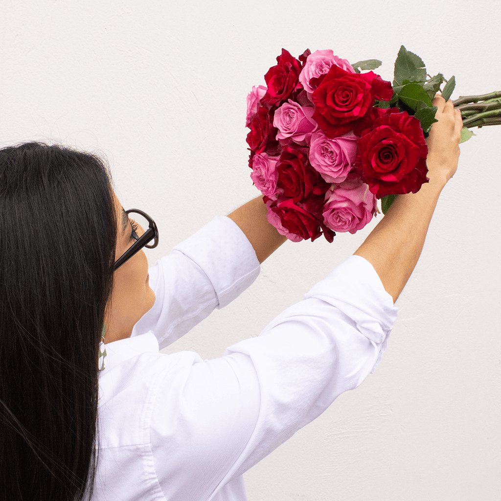 A young woman is holding a Velvet Passion Bouquet (Red Panther roses)