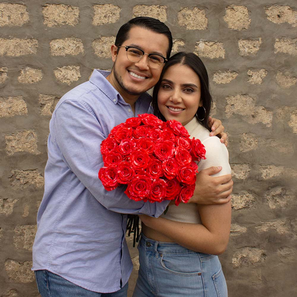 couple holding red striped roses - Wildcat bouquet