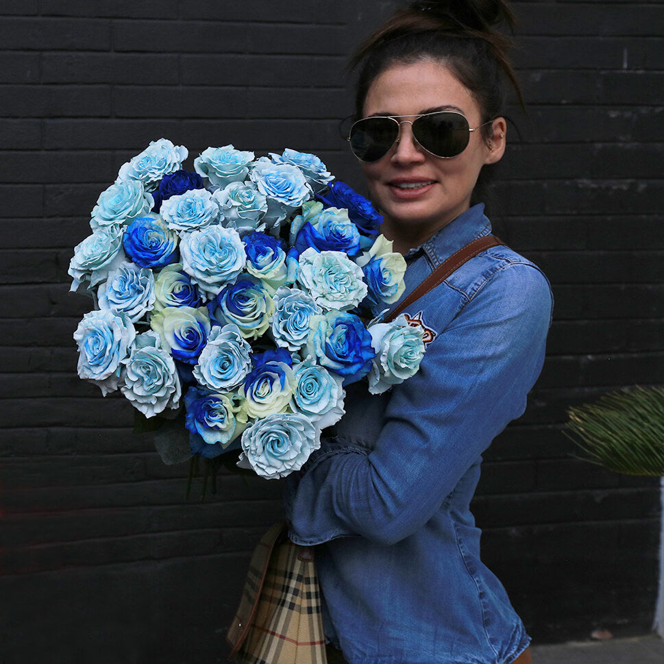 A young woman is holding a Blue Bay rose bouquet