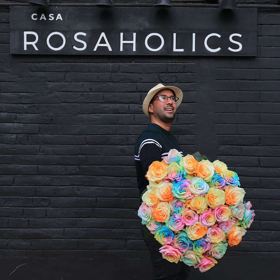 A man is holding a Cinnamon bouquet - multicolored roses