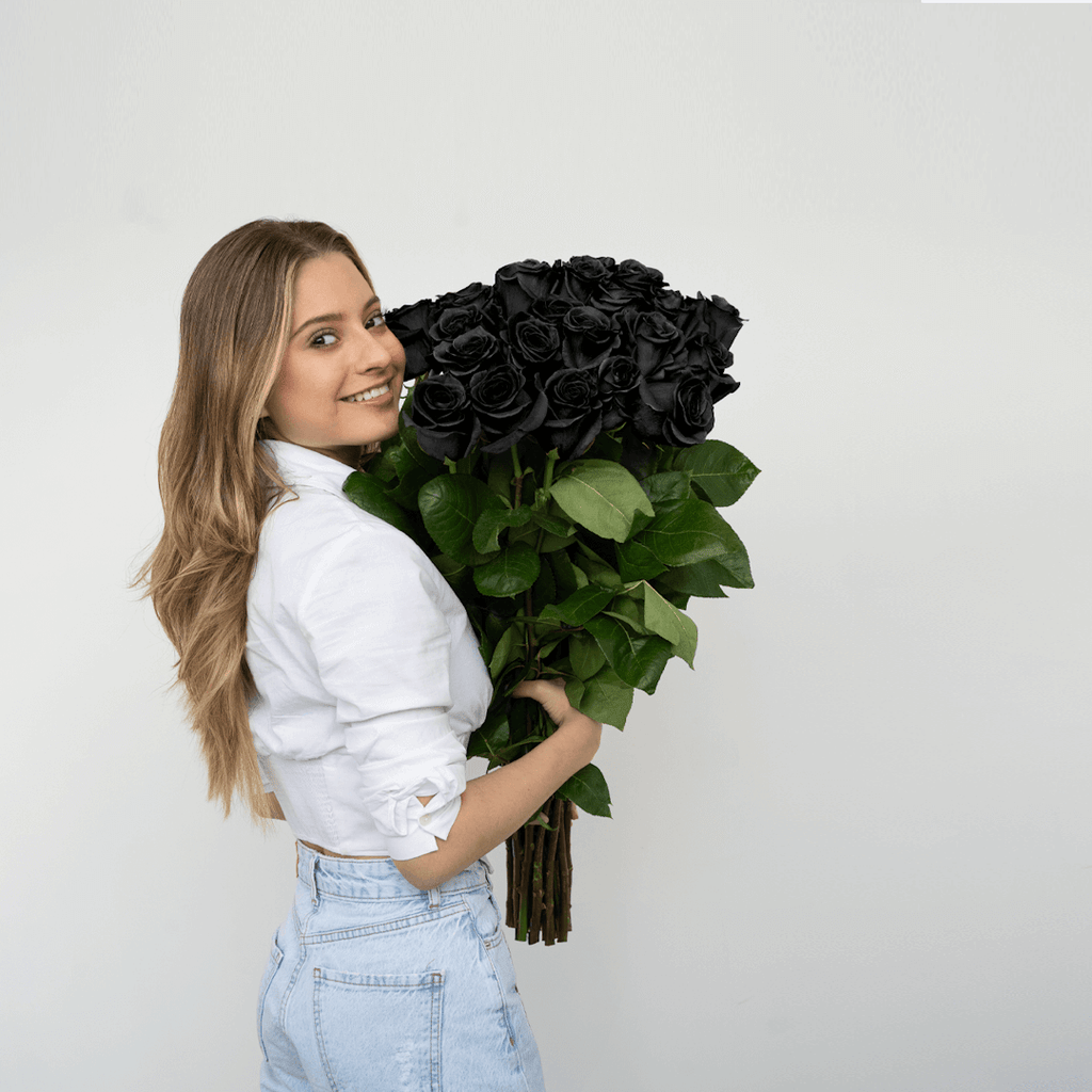 A woman holding a bouquet of black roses, called Black Mamba from Rosaholics