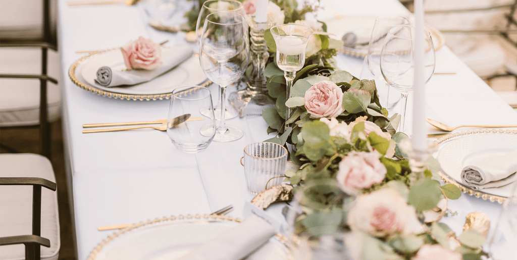 A wedding table set up with rose centerpieces.