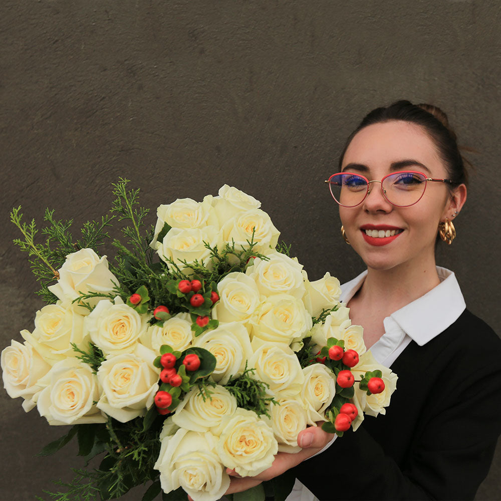 A girl is holding a bouquet of white Christmas roses