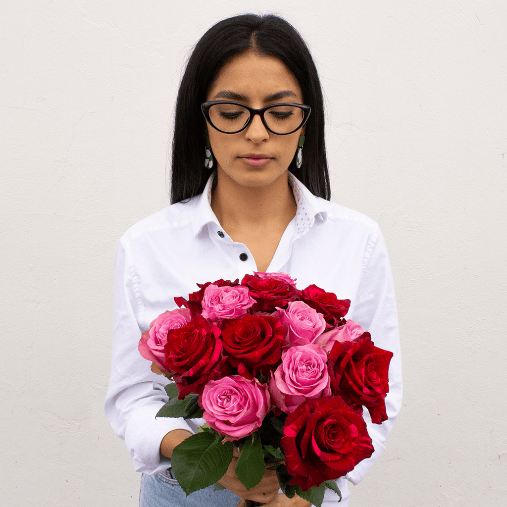 A young woman is holding a Velvet Passion Bouquet