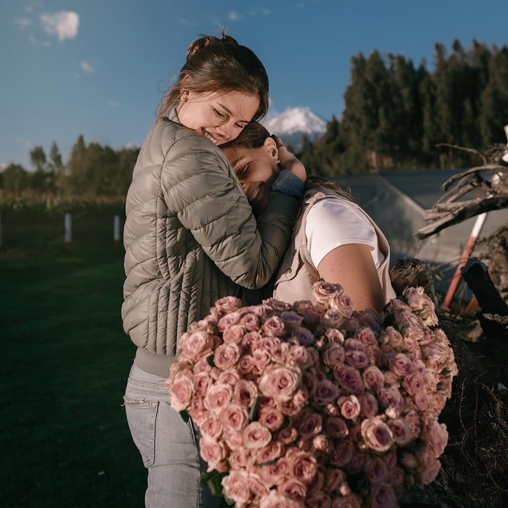 Two girls hugging after gifting some flowers because of a birthday