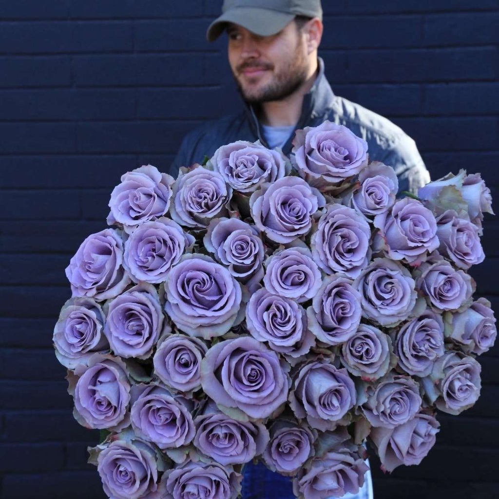 A man is holding bouquet of Lavender Roses