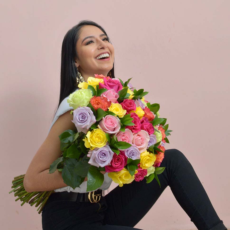 A woman is holding a Breathless Fresh colored rose bouquet