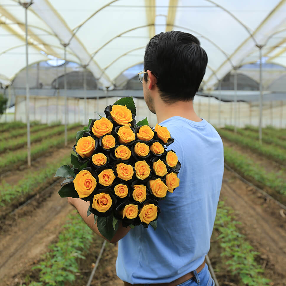 A man is holding bouquet of yellow and black roses - Bee Rose Bouquet by Rosaholics
