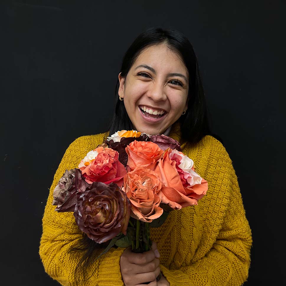 A young woman is holding a Cafe Tacuva bouquet - Fall roses