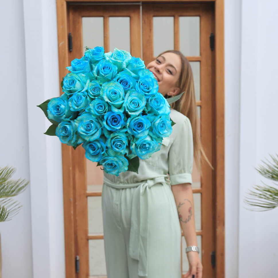 A girl is holding a Dry Snow aquamarine roses bouquet by Rosaholics