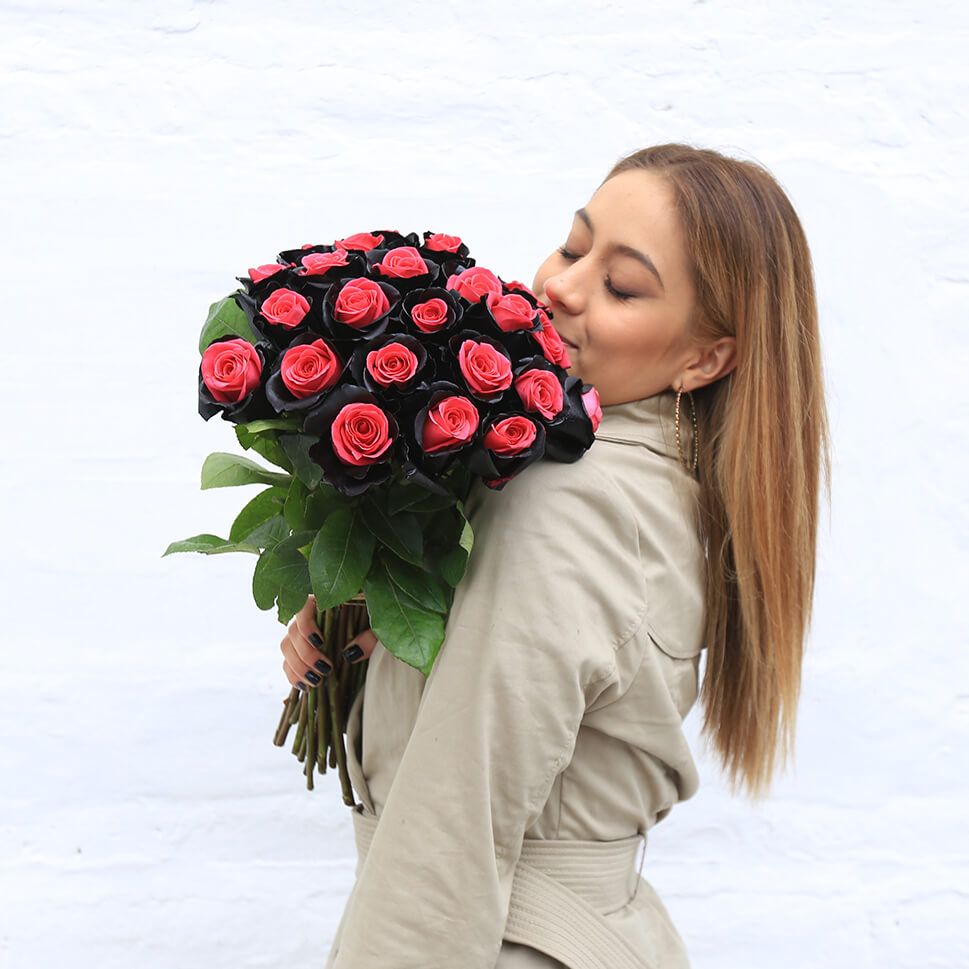 A young woman is holding a Eros rose bouquet