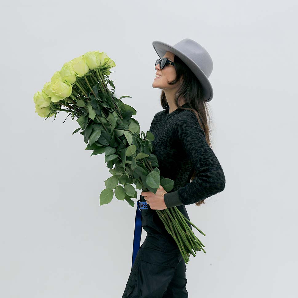 A girl is holding a bouquet of lemon long-stems roses