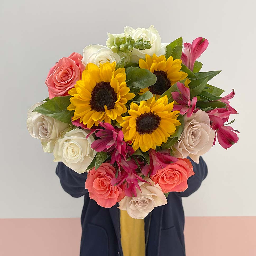 Person is holding Roses and Sunflowers Bouquet