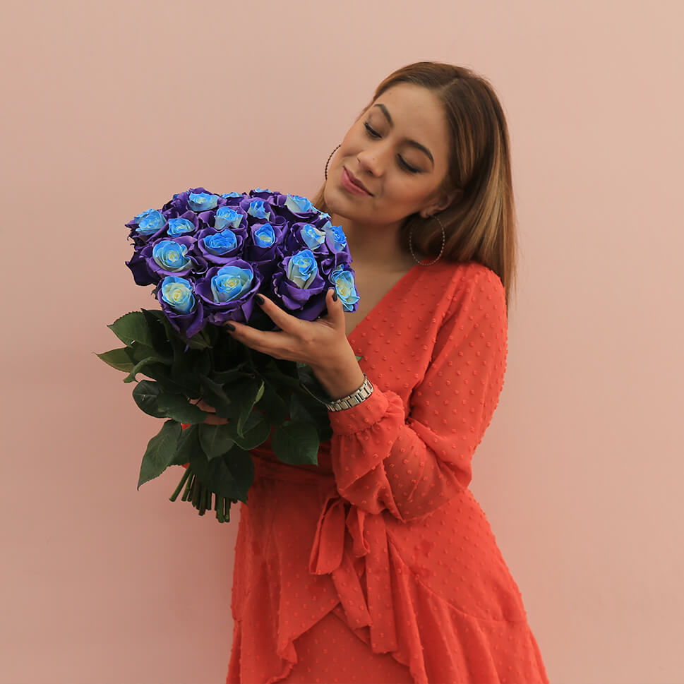 A young woman is holding a Lavender Gelato Rose Bouquet by Rosaholics